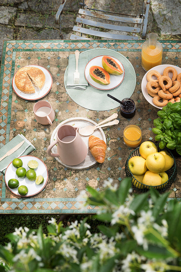 Frühstückstisch mit Obst und Gebäck im Garten