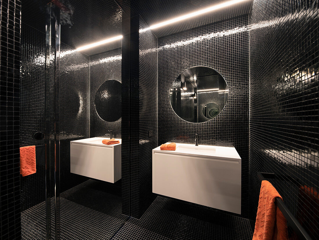 Modern bathroom with black mosaic tiles and mirrored wall