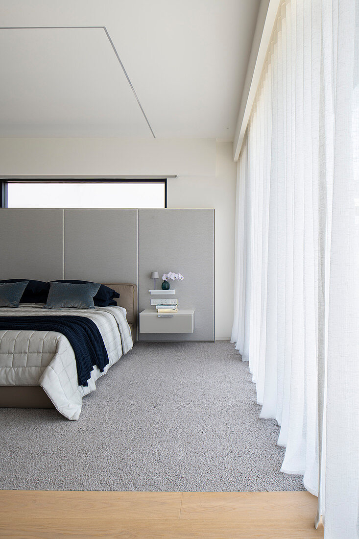 Modern bedroom in pale grey with panelled walls