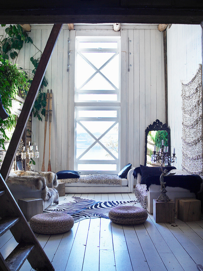 Orientalische Sitzecke mit vertikalem Fenster im alten Holzhaus