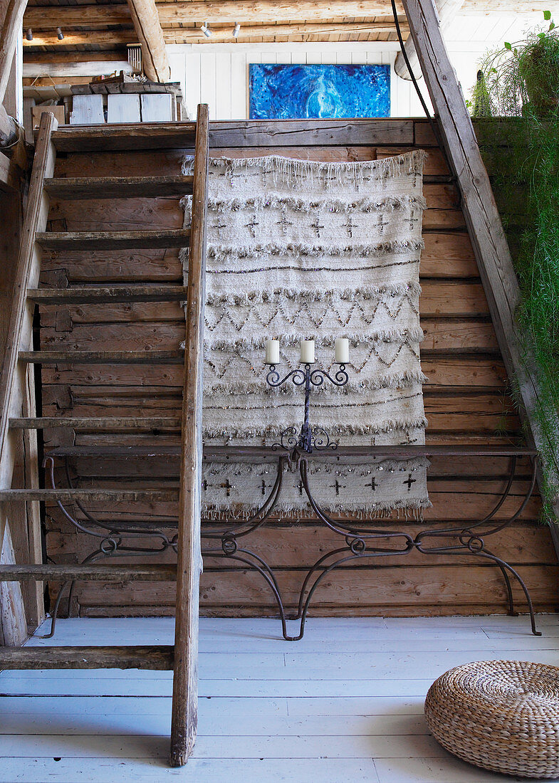 Zwei Konsolentische aus Metall an rustikaler Holzwand unter der Treppe