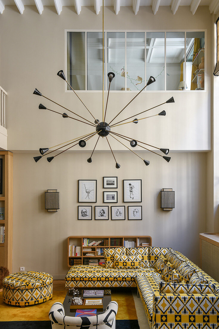 Starburst lamp above patterned sofa in living room