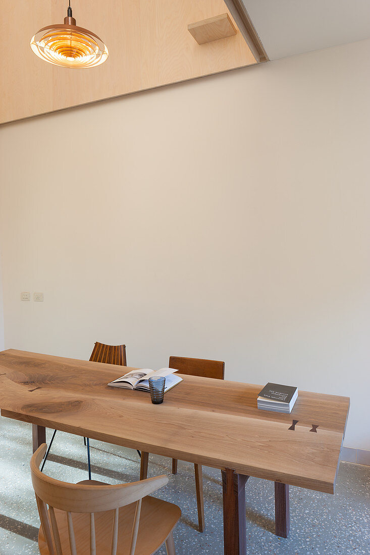 Holztisch mit verschiedenen Stühlen im minimalistischen Esszimmer