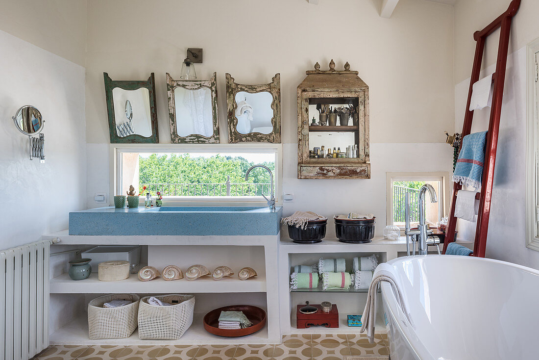 An eclectic bathroom with shelves and a mirror