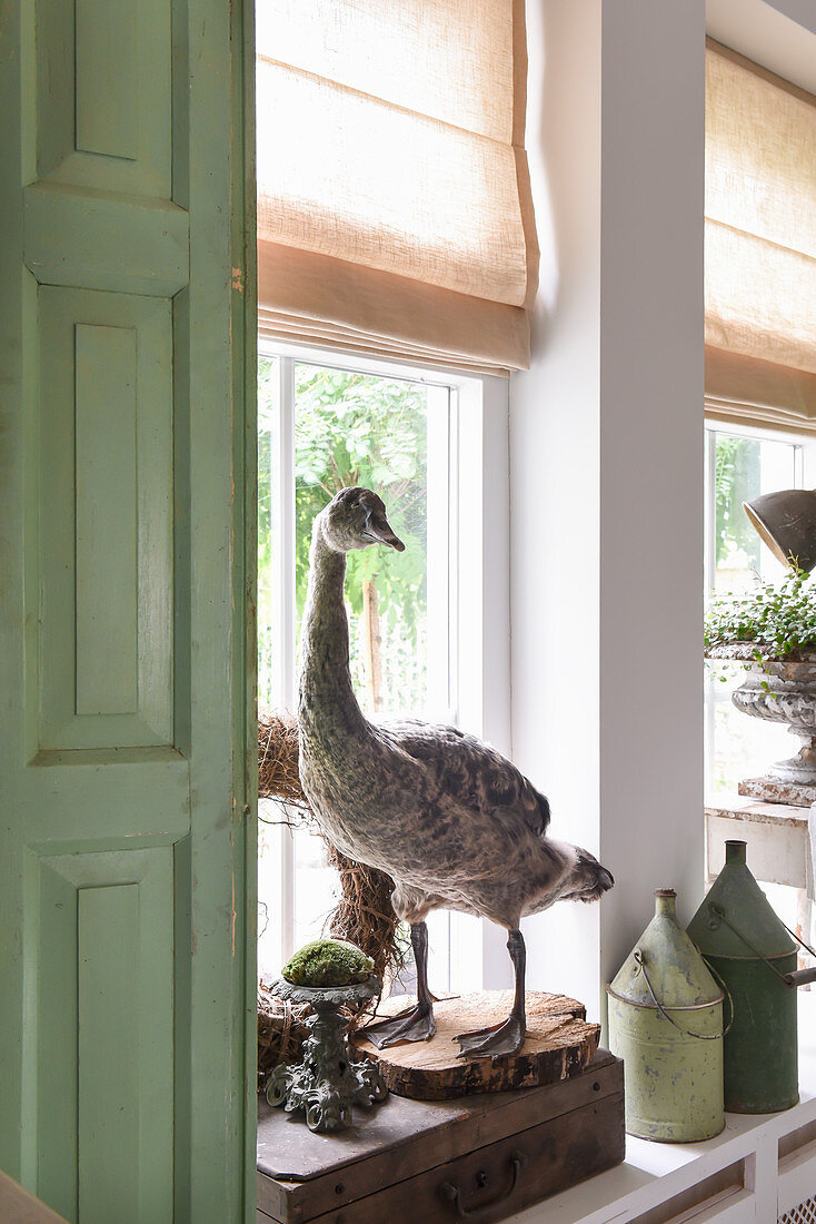 A stuffed goose in front a window