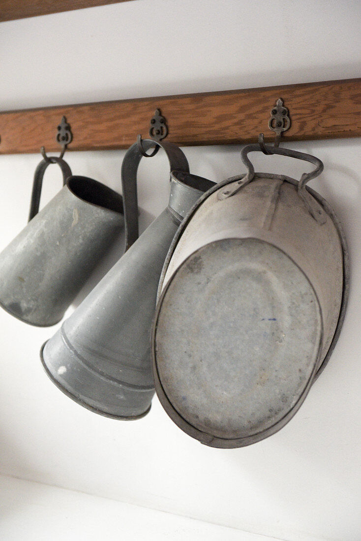 Old zinc containers on hooks