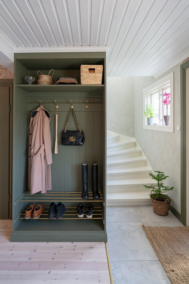 An open wardrobe with a shoe rack in a hallway