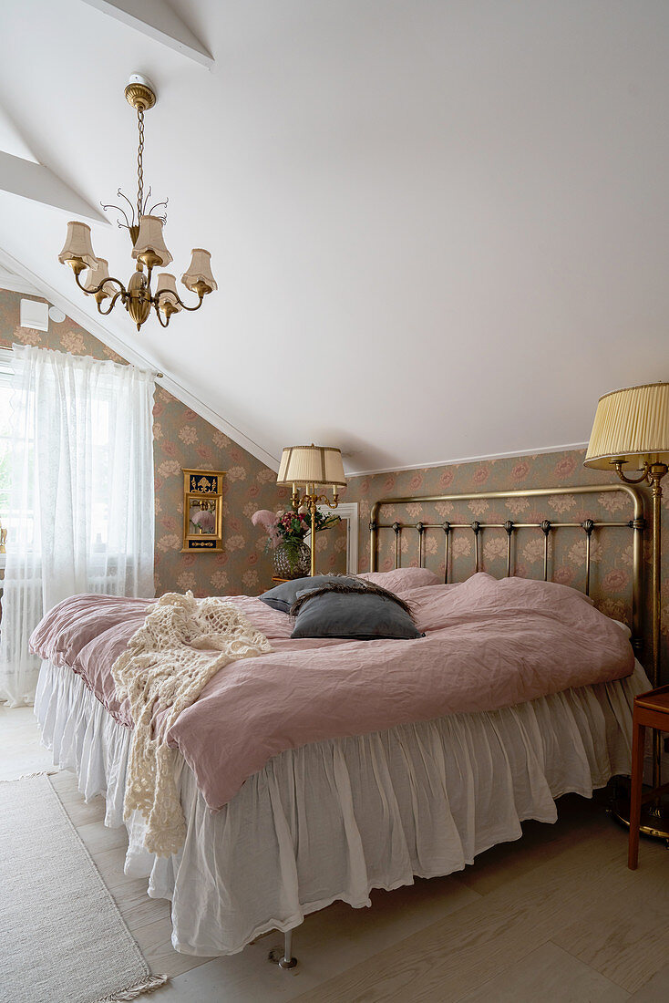 A brass double bed in an attic bedroom