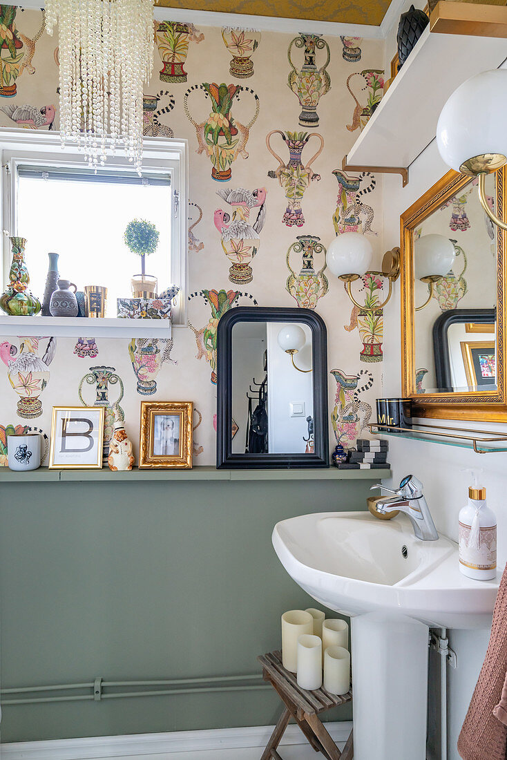 A pedestal washbasin in a wallpapered guest toilet