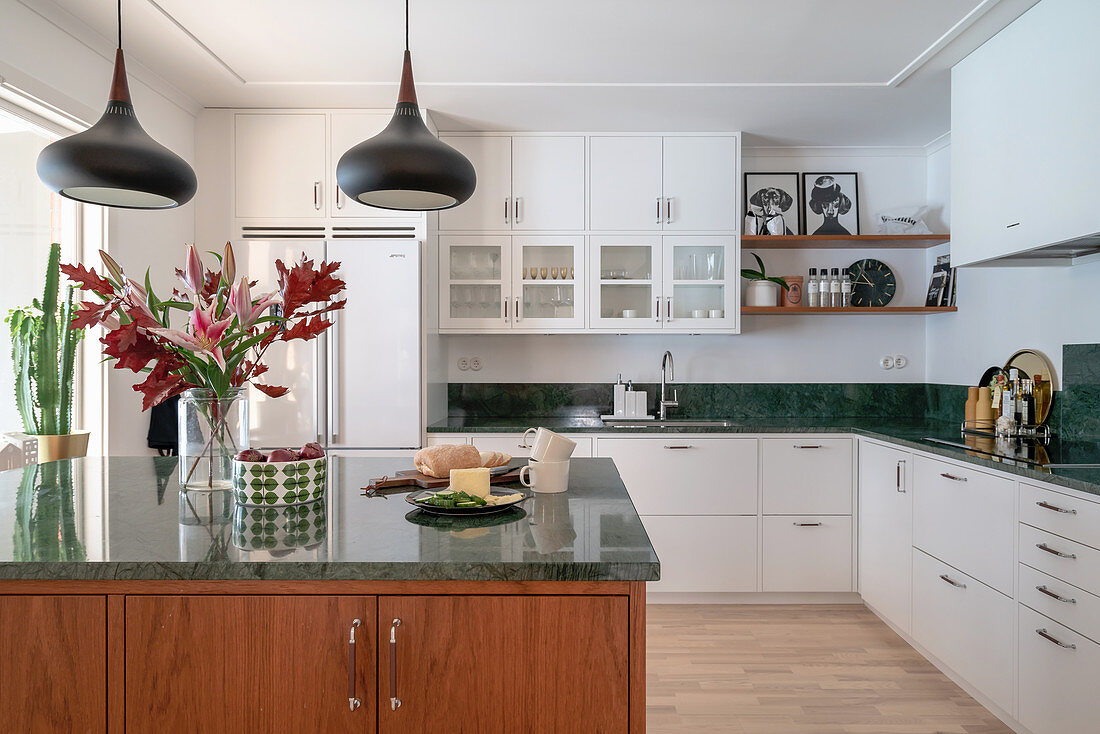 Open kitchen with green marble worktop, kitchen island and dining area