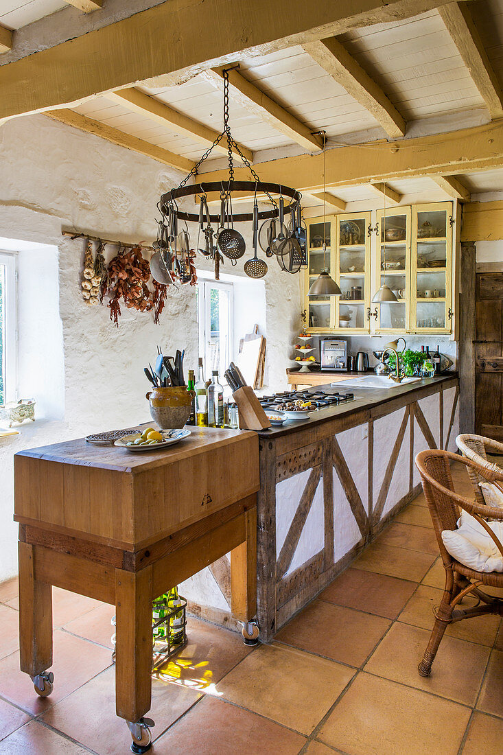 Long counter in a country kitchen with wooden ceiling beams