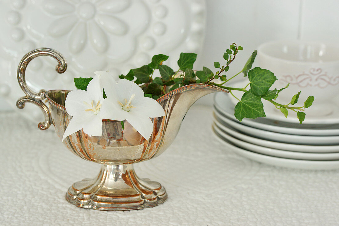 Silver gravy boat decorated with ivy tendrils and white campanula flowers
