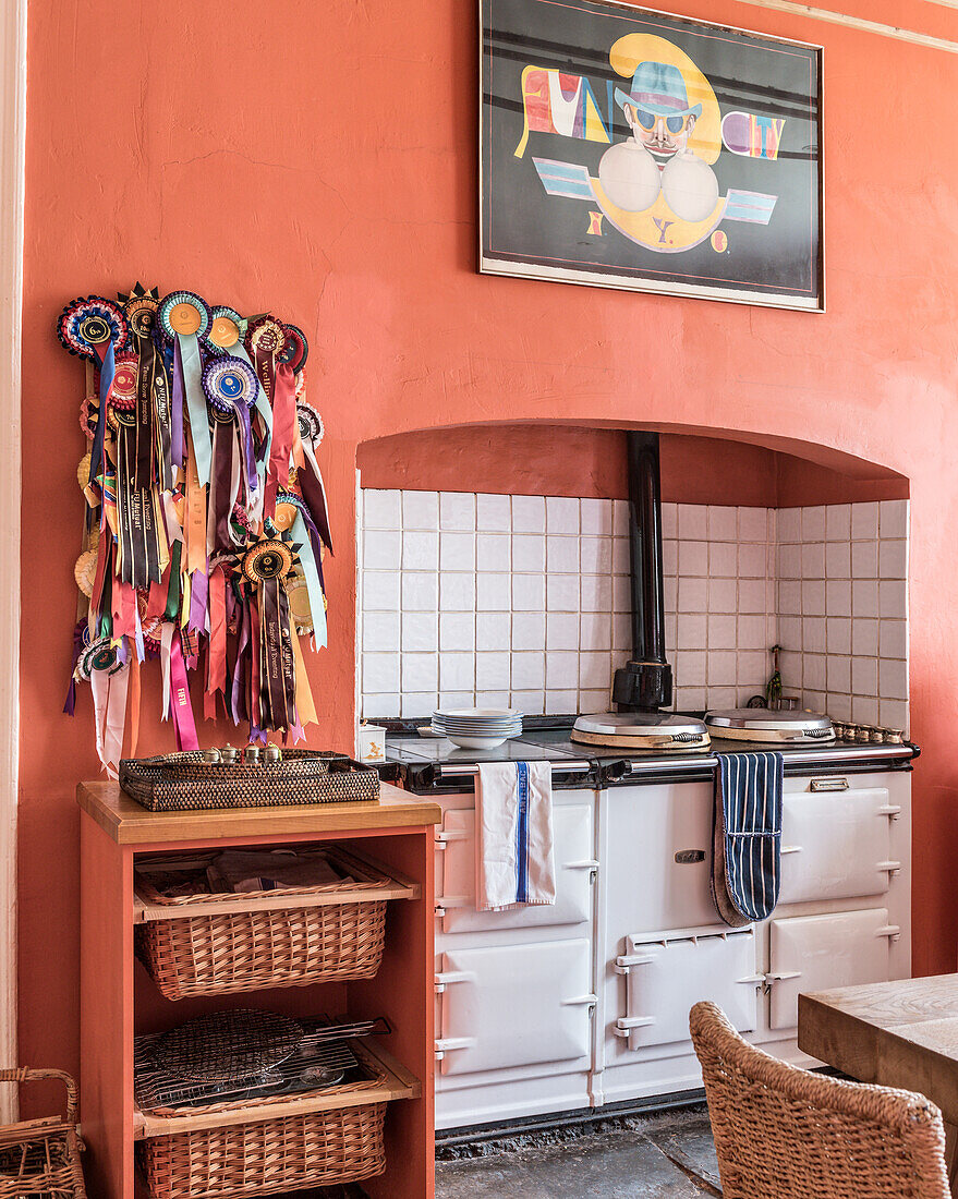 Eine Sammlung von Kokarden an terrakottafarbener Wand in einer Landhausküche