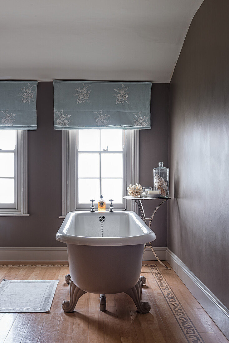 Freistehende Badewanne im Bad mit hellblau bestickten Vorhängen im restaurierten Bauernhaus