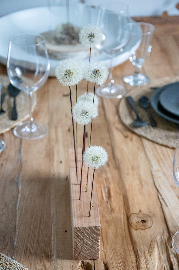 Pusteblumen in Holzleiste als Tischdekoration