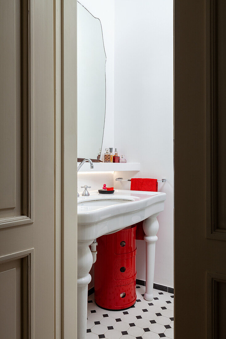 Vintage washbasin above red cabinet in bathroom