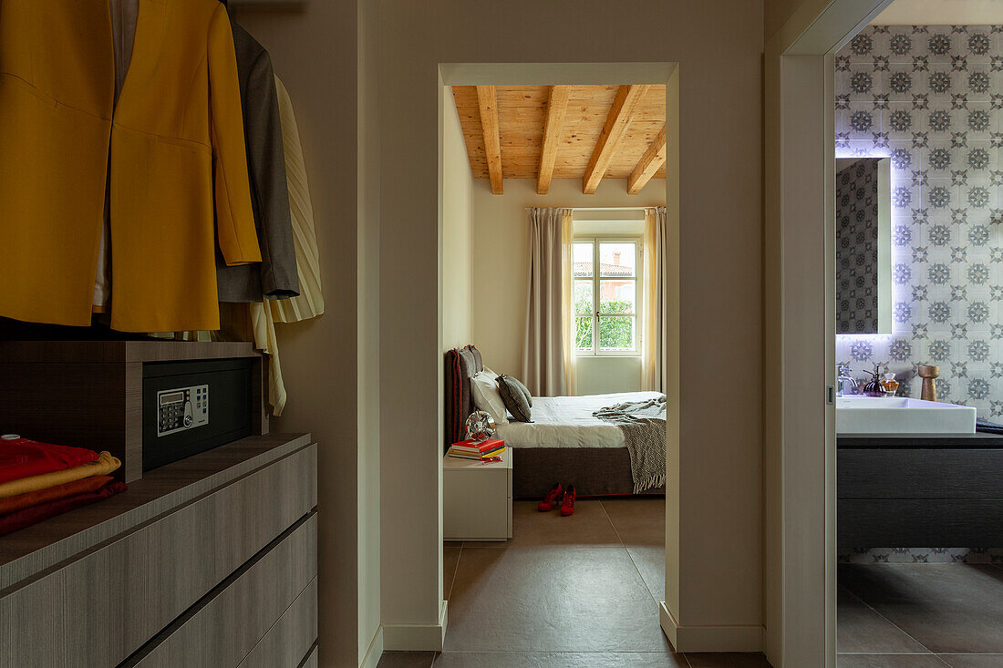 An anteroom with a wardrobe and a safe with a view into a bathroom and a bedroom