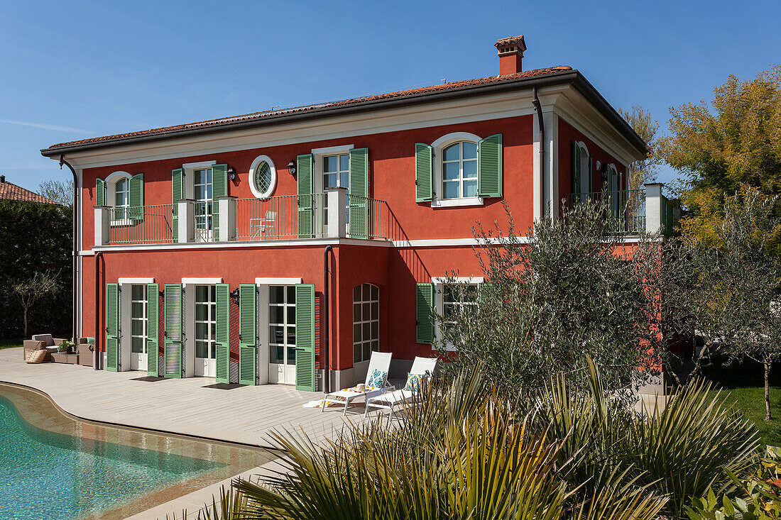 A two-storey villa with green shutters