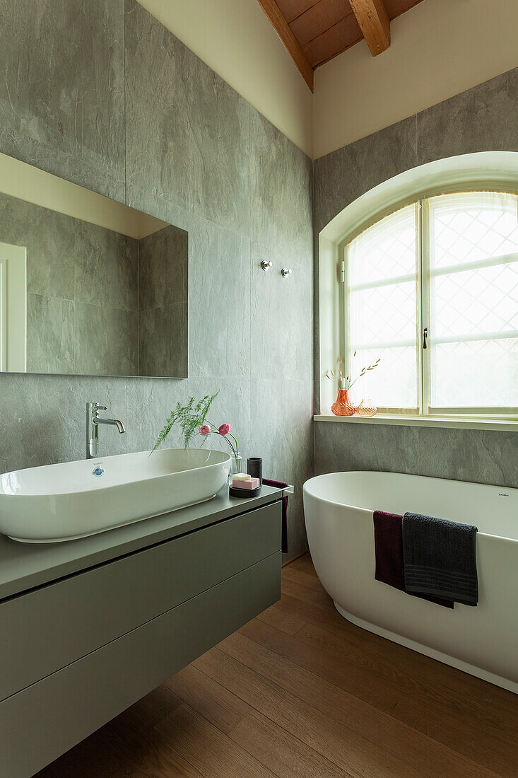 A washstand with a countertop basin and a freestanding bathtub in a bathroom