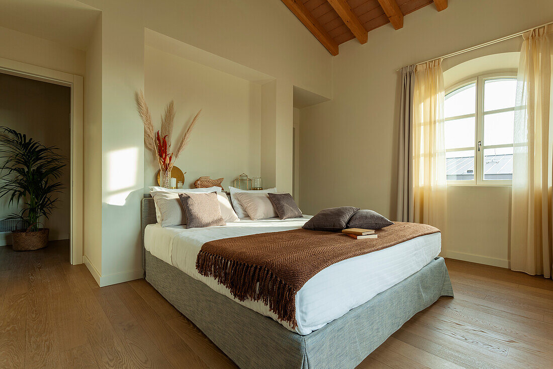 Doppelbett im Schlafzimmer mit cremefarbenen Wänden