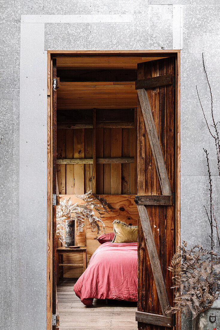 Blick ins rustikale Schlafzimmer auf handgefertigtes Futonbett