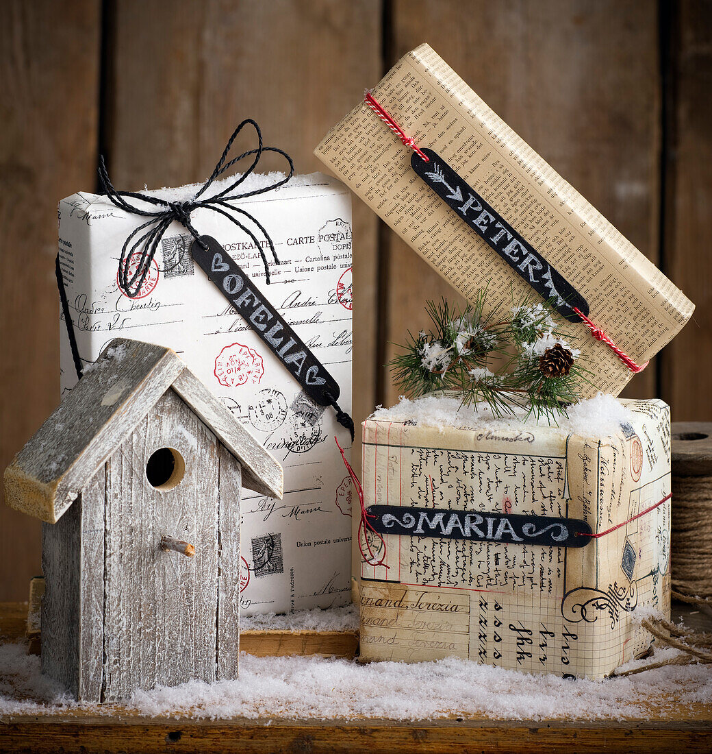 Festively wrapped presents with name tags and a birdhouse