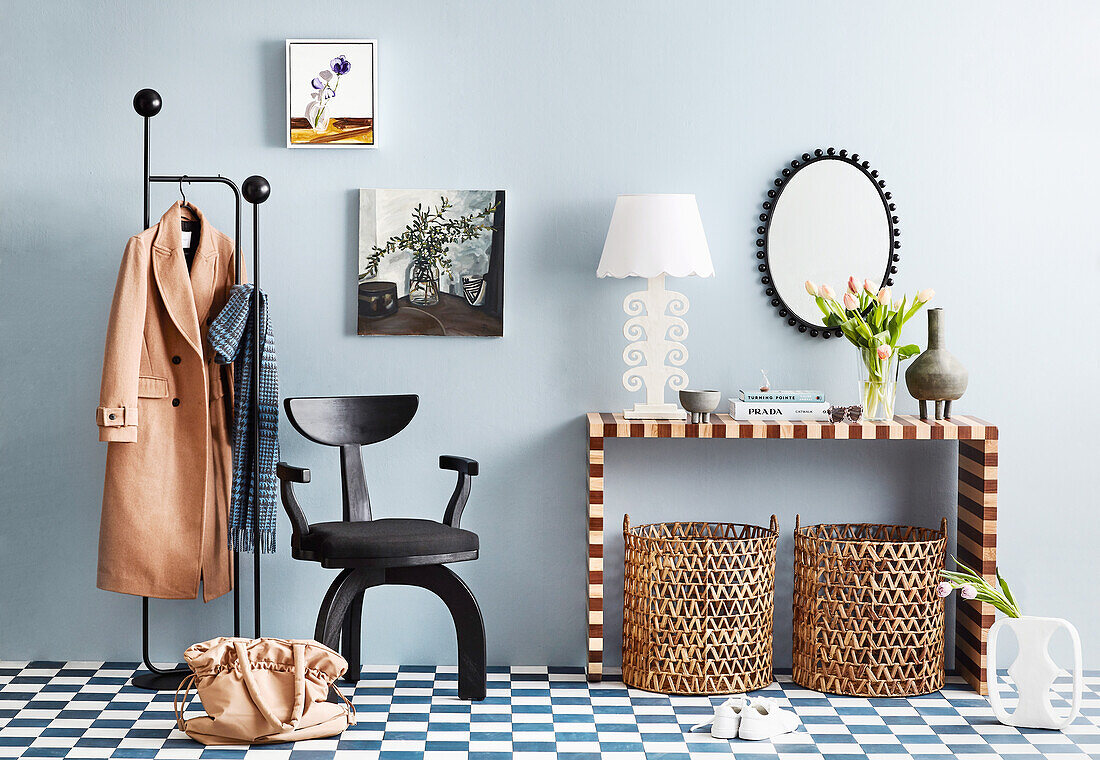 Konsolentisch, Designerstuhl und Garderobenständer in der Diele mit blauen Wänden