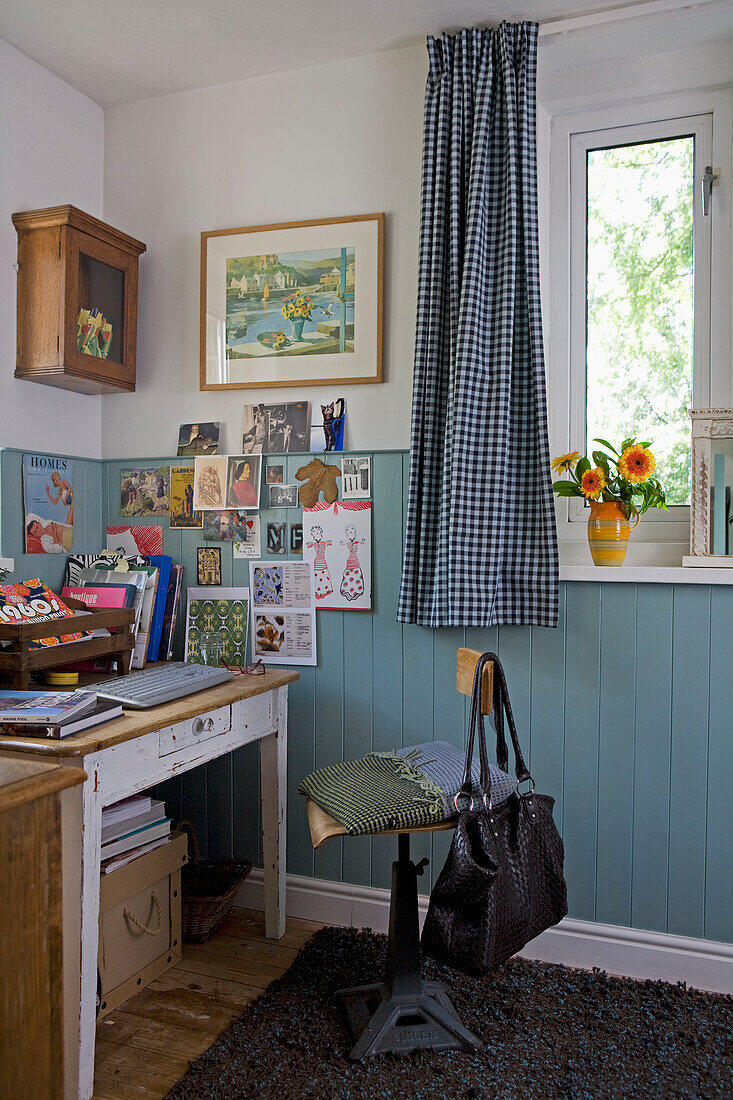 Blau karierte Vorhänge am Fenster im Arbeitszimmer mit türkisfarbener Vertäfelung und Schreibmaschinenstuhl aus den 50er Jahren am Schreibtisch