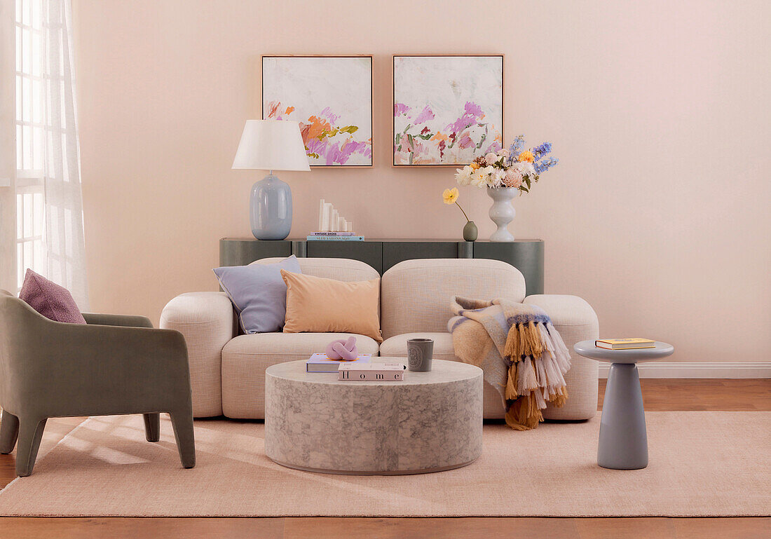 Bequemes Sofa, Konsole, runder Marmortisch und Armlehnstuhl im pastellfarbenen Ambiente
