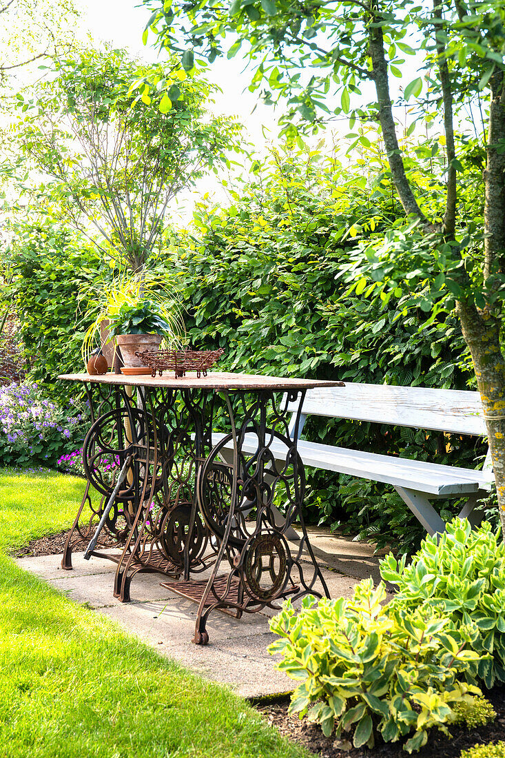 Cozy outdoor seating area with garden table made from two sewing machines and bench