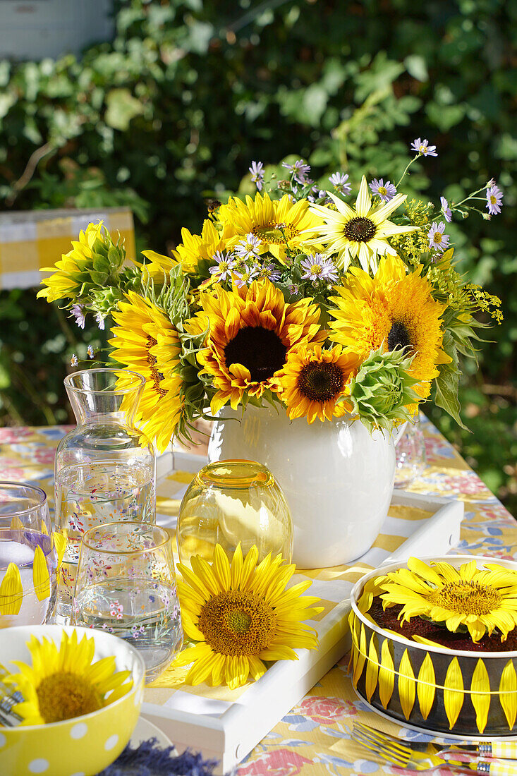 Bouquet of sunflowers on outdoor table with sunflower cake