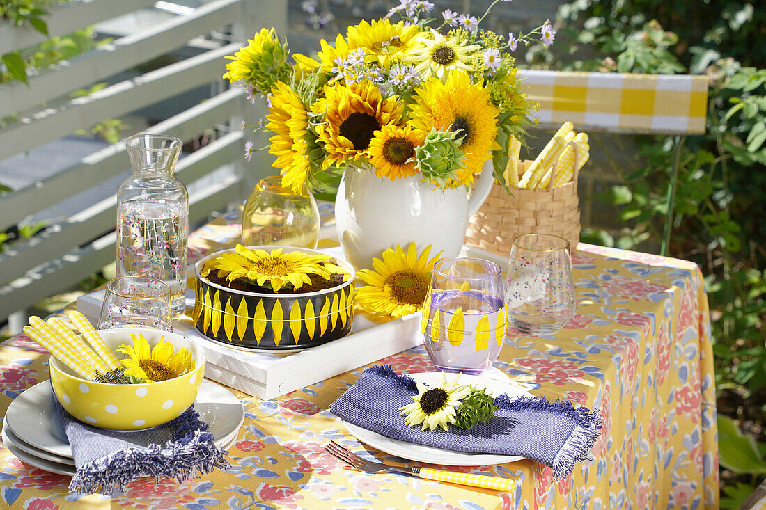 Gedeckter Tisch mit Sonnenblumenstrauß im Freien