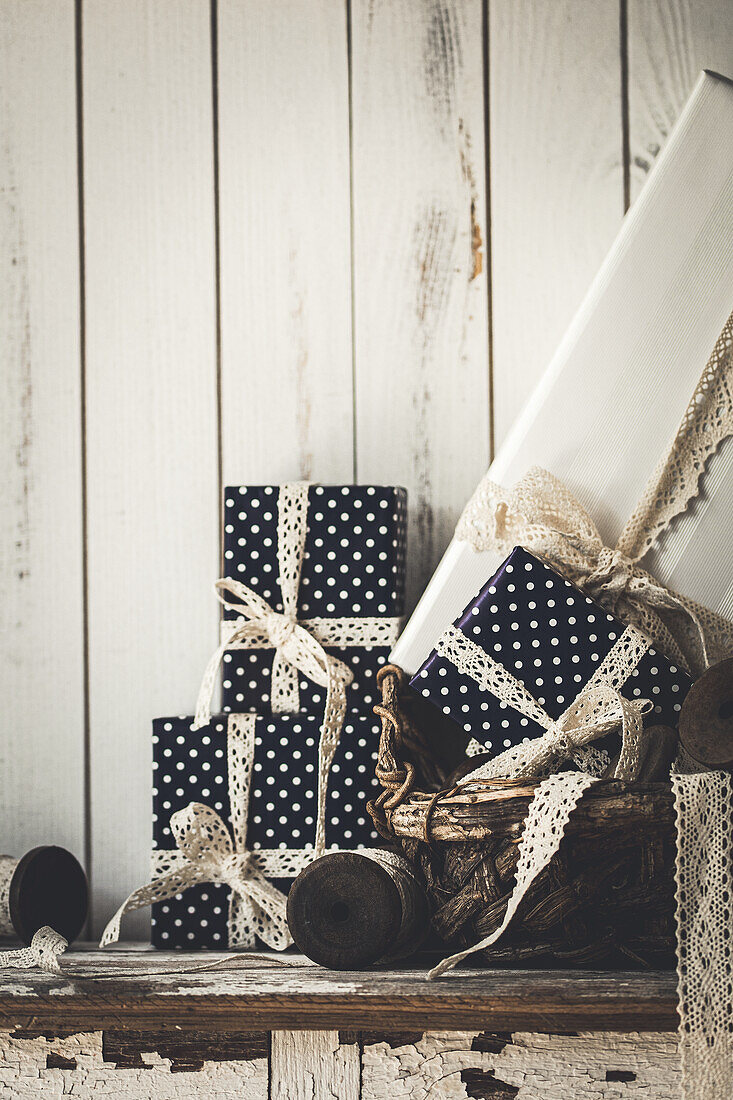 Christmas presents wrapped in black and white dotted wrapping paper with lace border
