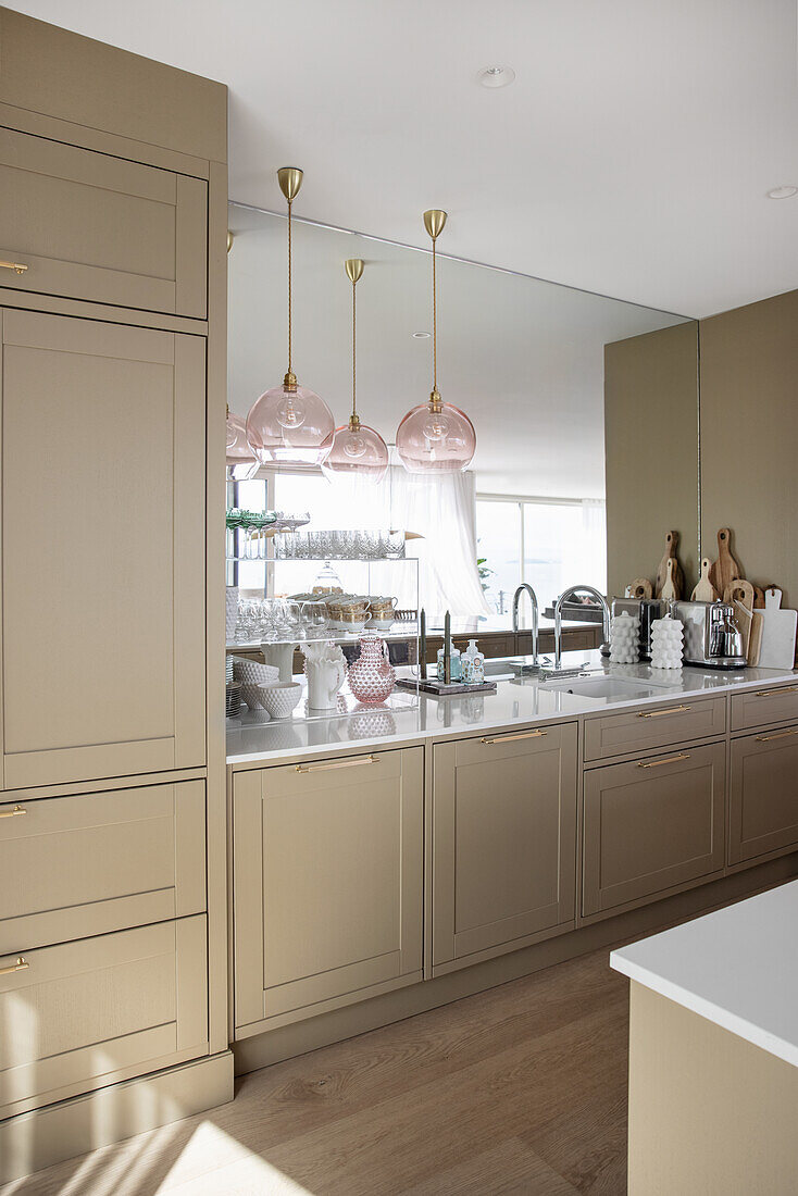 Elegante, beigefarbene Küche mit Spiegelwand
