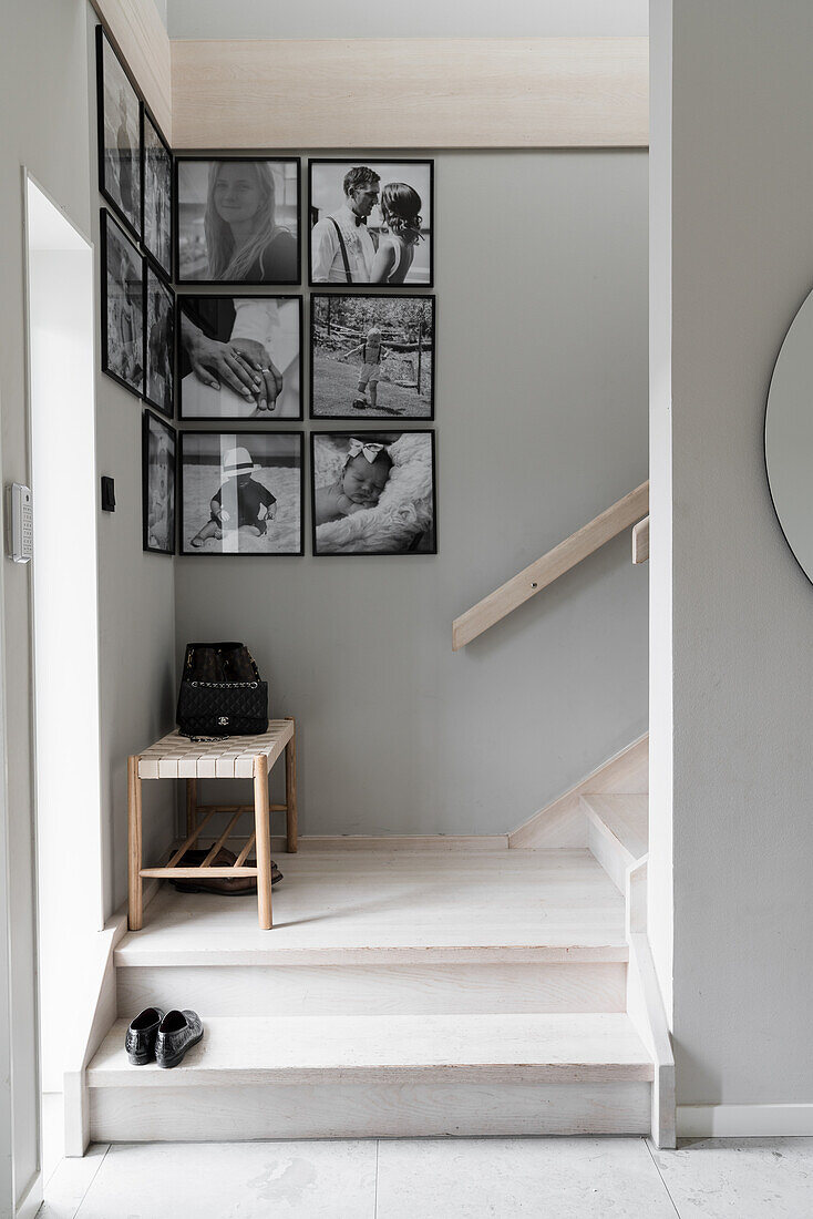 Helles Treppenhaus mit schwarz-weißer Fotogalerie