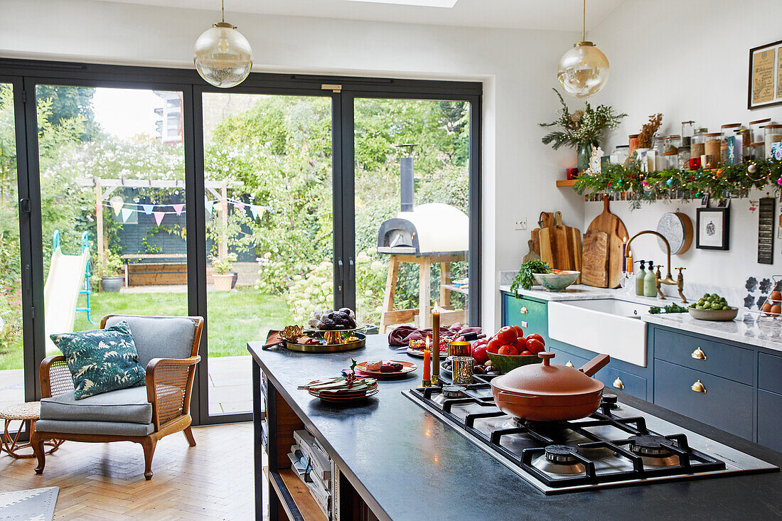 A cooking island with a gas cooker in an open-plan room with terrace access
