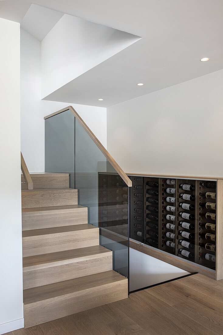 Weinschrank in elegantem Treppenhaus mit Holzstufen