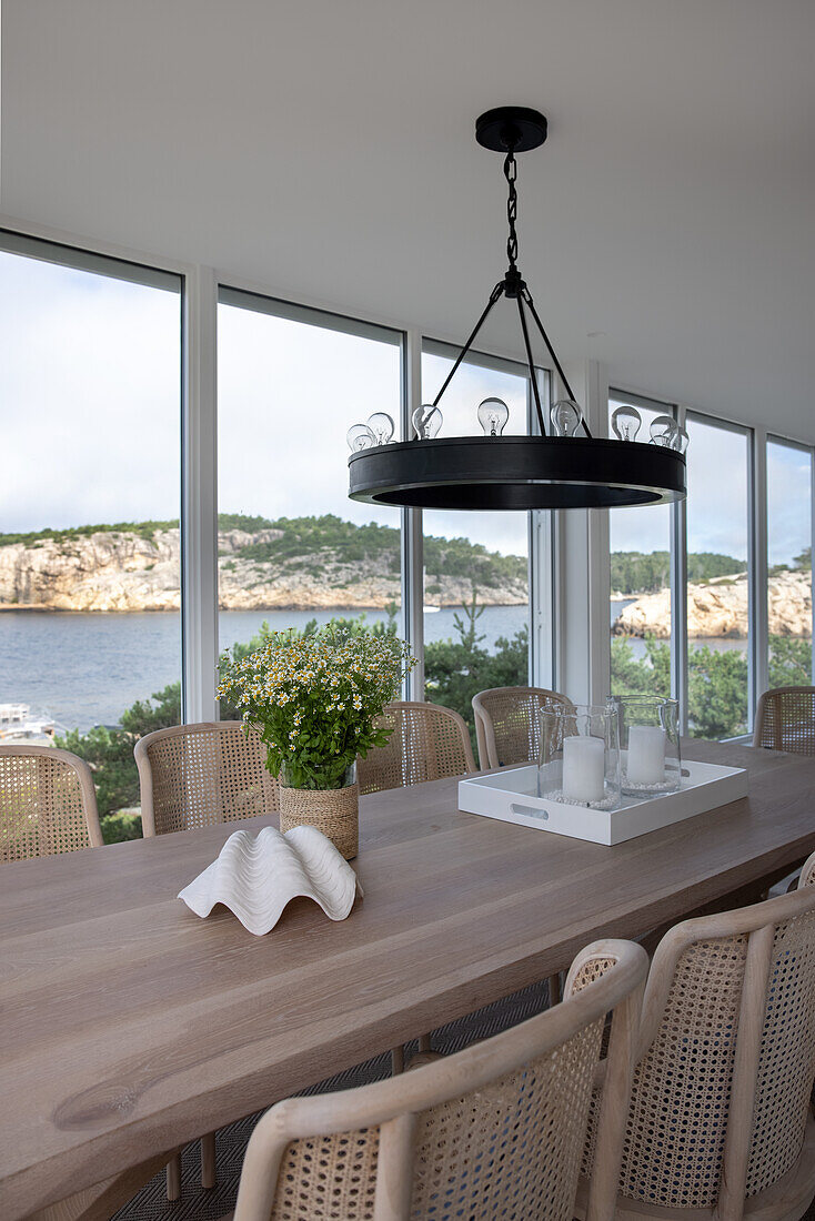 Dining area in front of glass front, view of coastal landscape