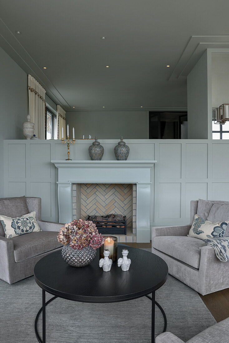 Comfortable armchairs and coffee table in front of the fireplace