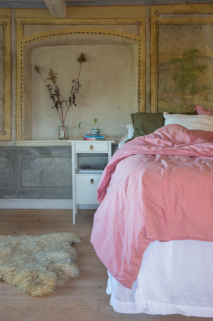 Doppelbett im Schlafzimmer mit Wandmalerei
