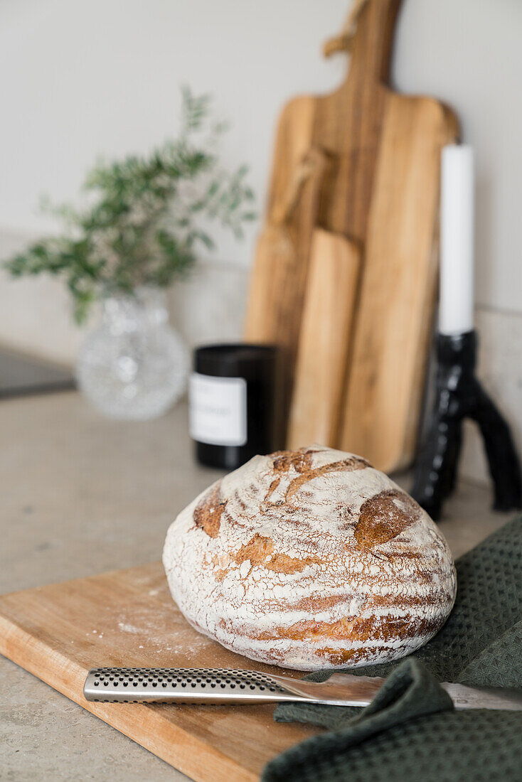 Bread, wooden boards and candle on kitchen worktop