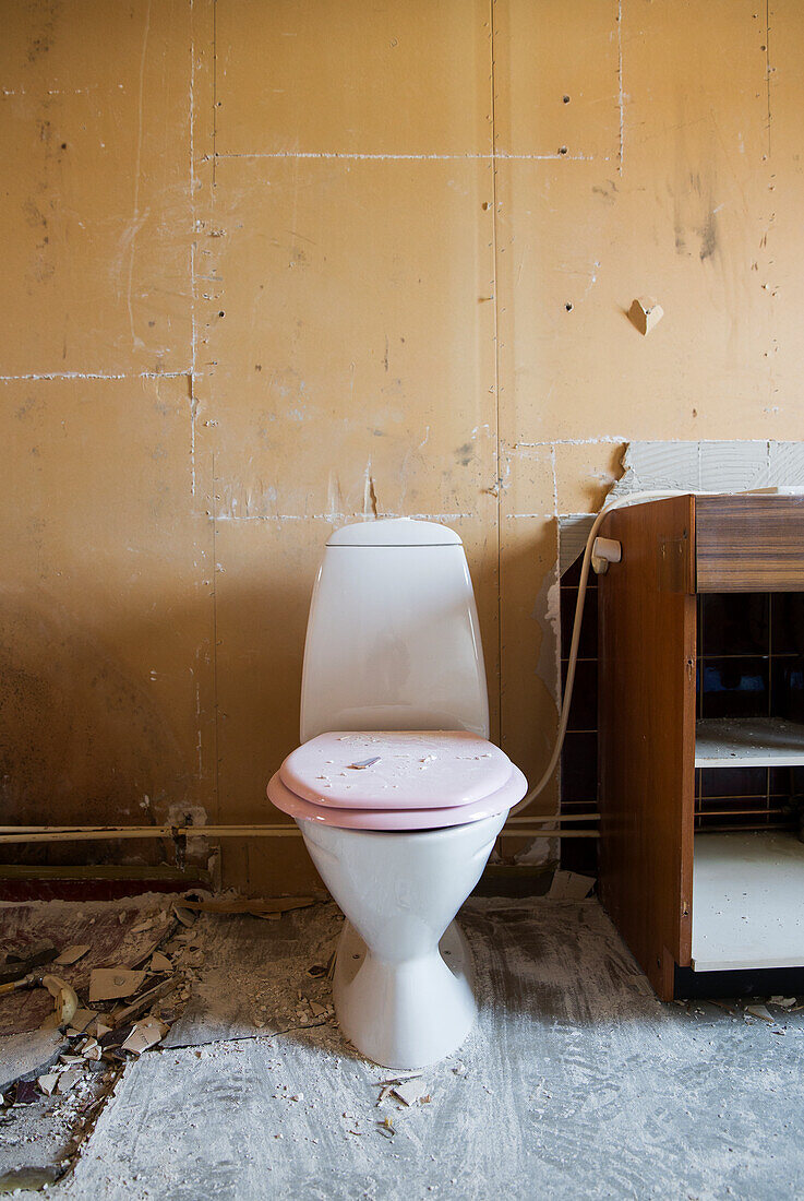 Toilette im schmutzigen Badezimmer während der Renovierung