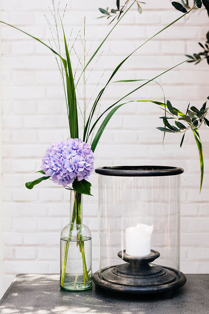Flower in vase next to candle