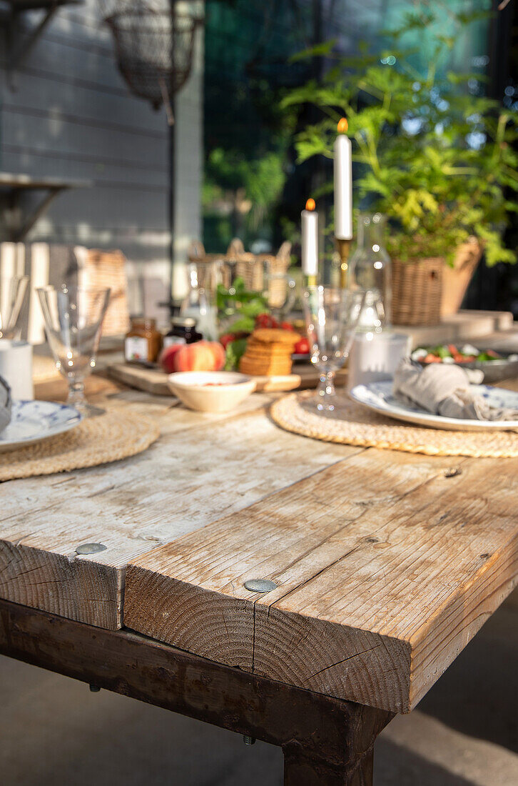 Gedeckter Tisch mit Holzbrettern auf der Terrasse