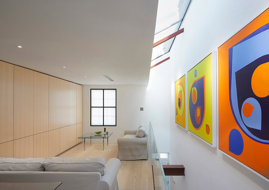 Lounge im Obergeschoss mit Oberlicht und moderner Kunst