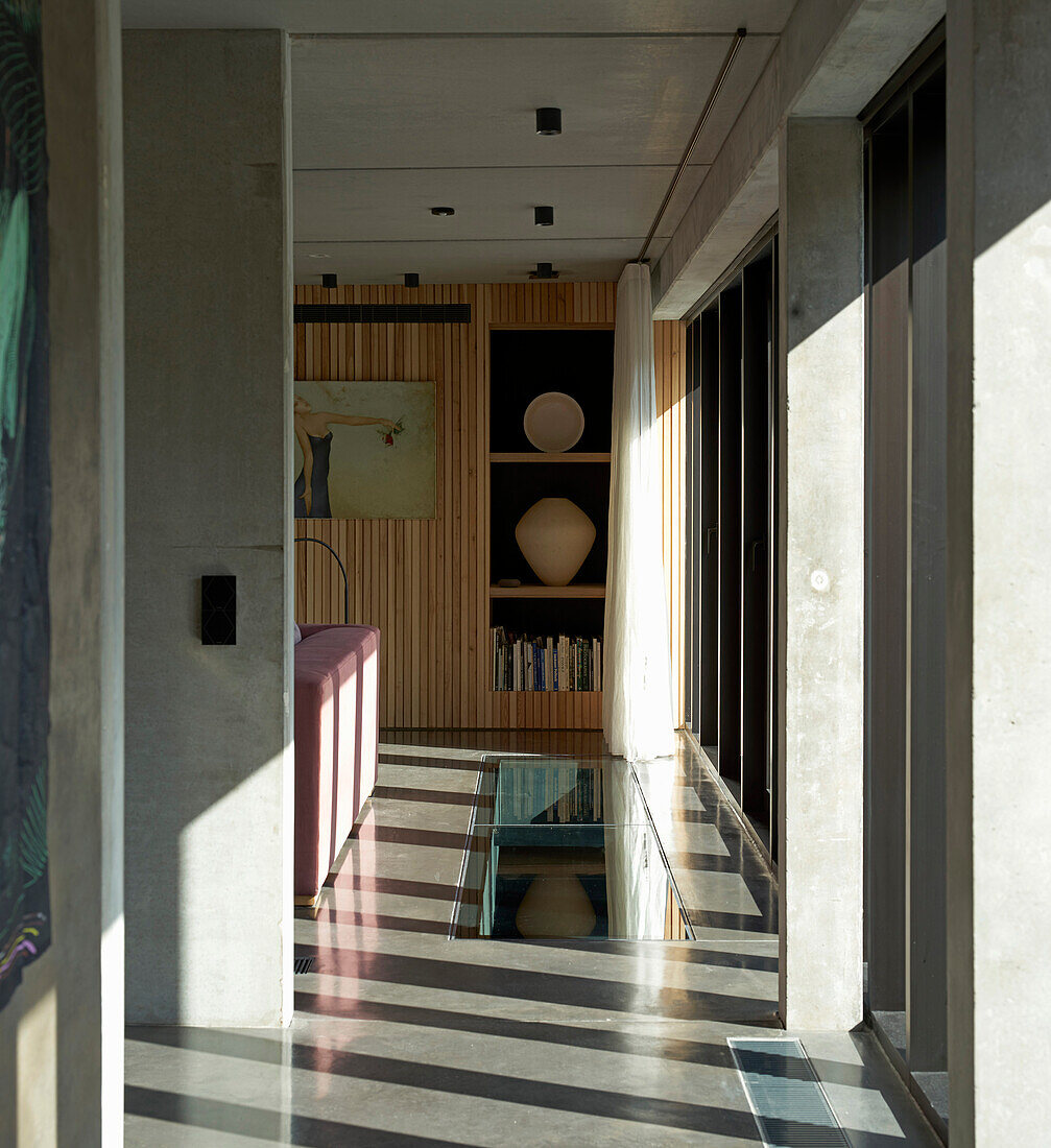 Blick durch geöffneter Schiebetür auf Holzregal im Architektenhaus
