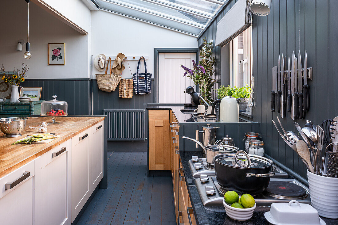 Offene Küche mit Kücheninsel, graue Holzverkleidung an den Wänden