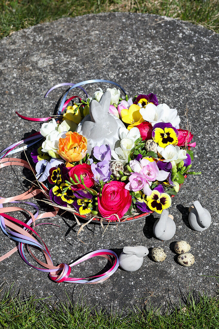 Flower bowl with Easter bunny figurine on concrete slab