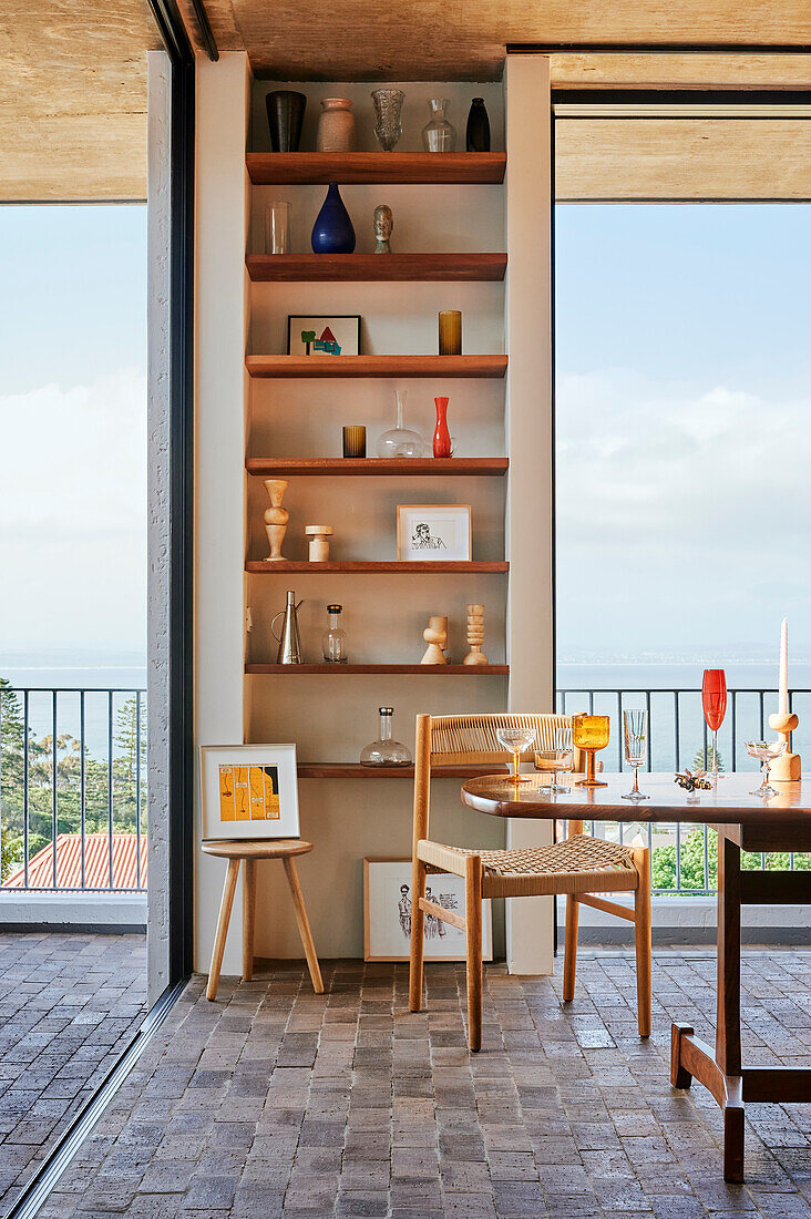 Essbereich mit Retro Tisch und Regalen in Wandnische, Blick auf das Meer