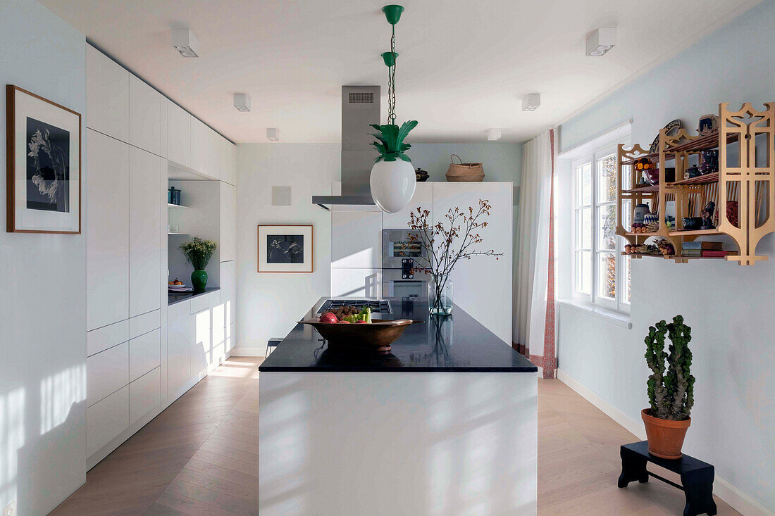 Elegante weiße Küche, Kücheninsel mit schwarzer Granitplatte